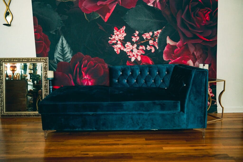 Teal velvet couch boudoir set with oversized dark red floral wall inside a Fort Worth boudoir studio.